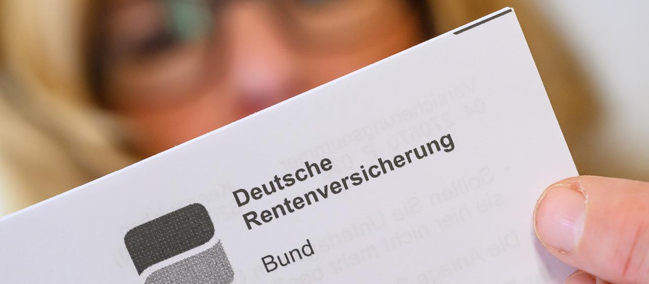 Eine Frau hält einen Brief der Deutschen Rentenversicherung in der Hand.