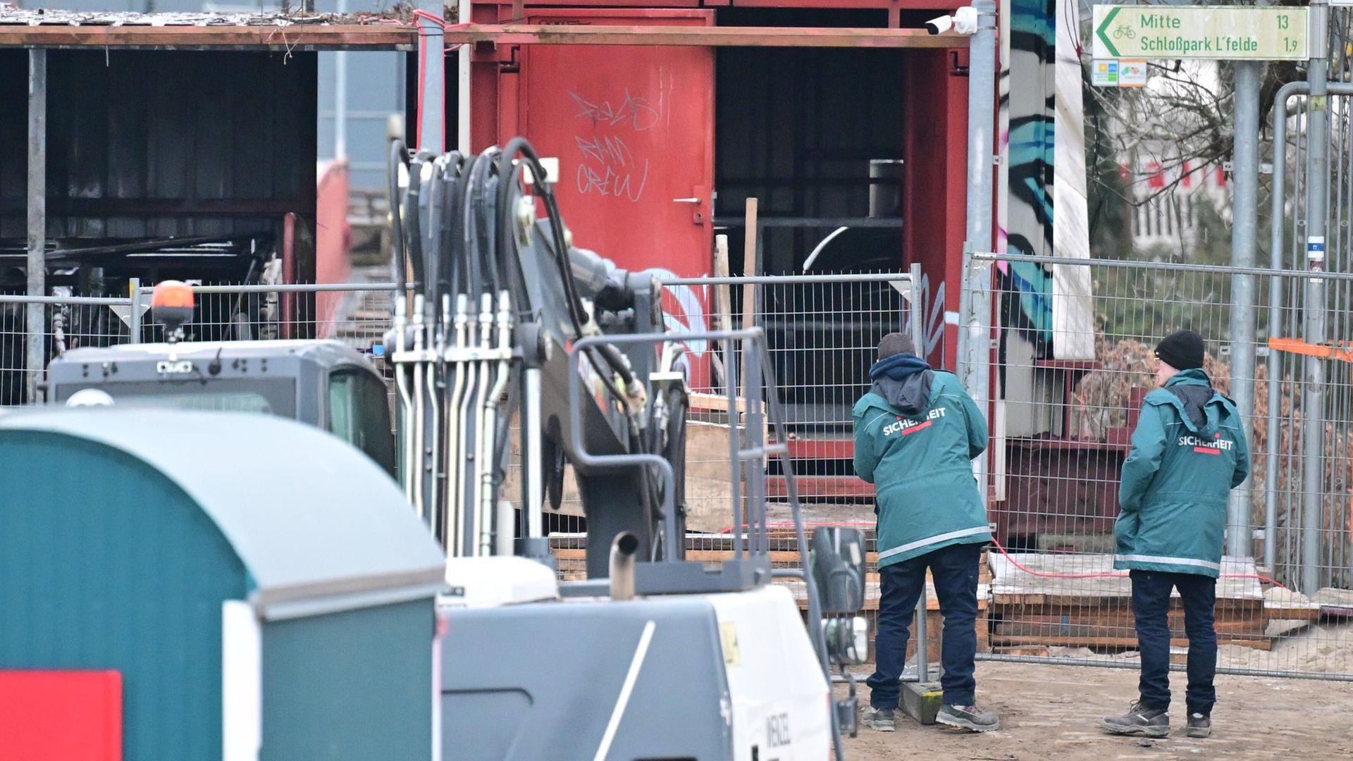 Sicherheitsmänner stehen an der Baustelle an der Kabelbrücke, die Anfang Januar durch einen Brandanschlag beschädigt wurde. Bild: dpa/Sebastian Gollnow | dpa/Sebastian Gollnow