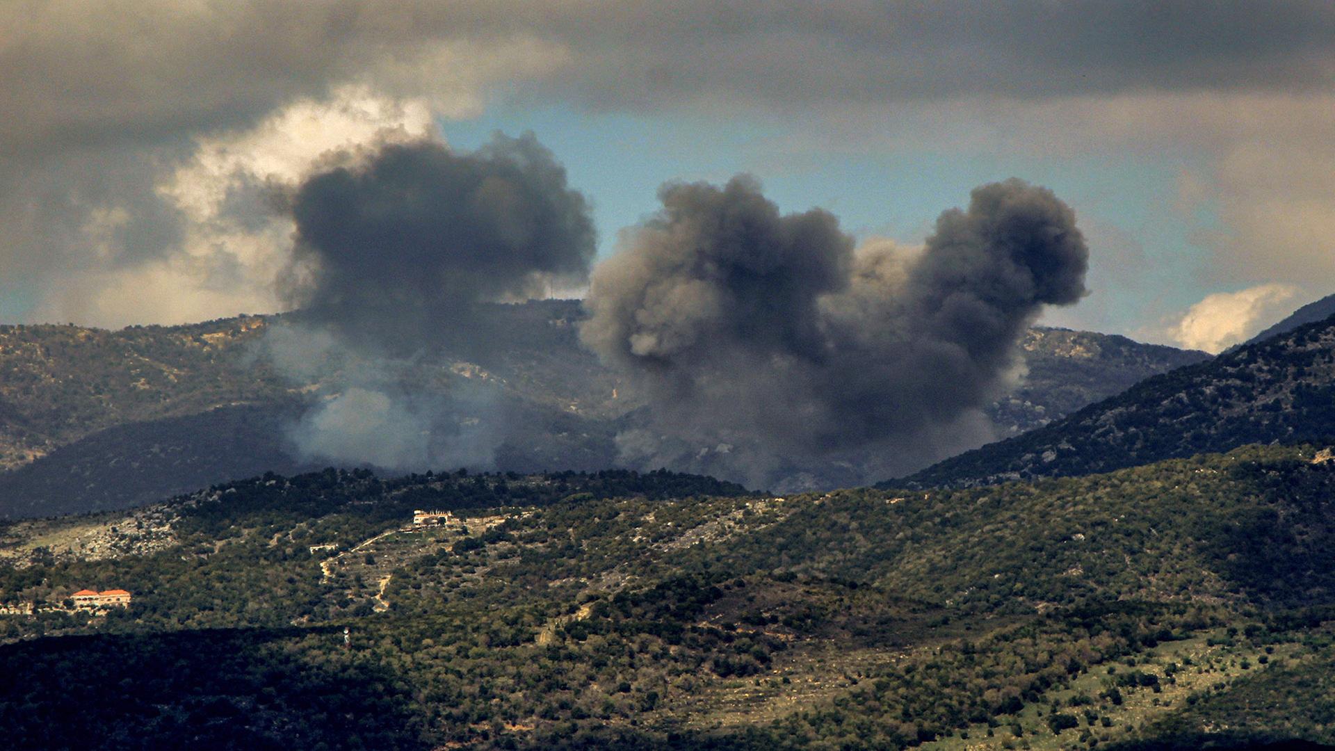 In einem bergigen Gelände steigt schwarzer Rauch auf. (Archivbild: 22.3.2025) | STR/dpa