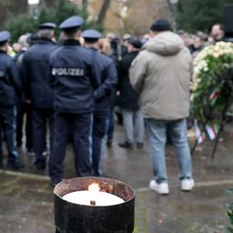 Trauernde stehen nach einer Kranzniederlegung in einem Park in Aschaffenburg.