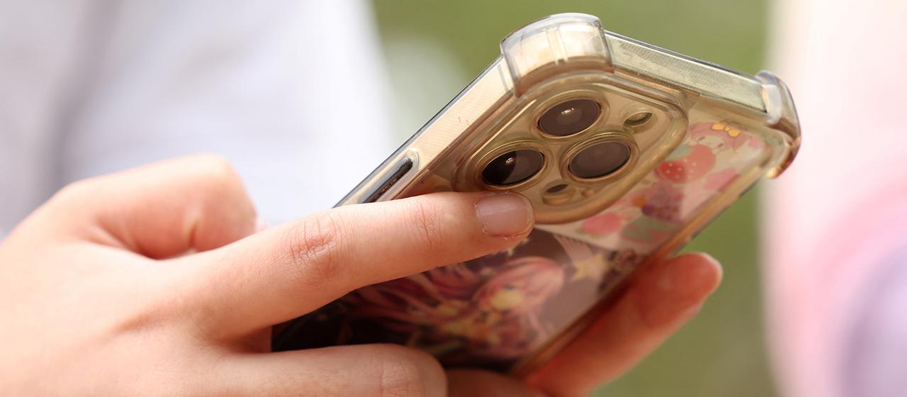 Ein Mädchen hält ein Handy in den Händen.