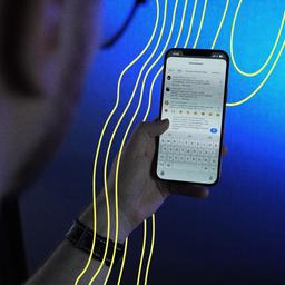Mann mit Smartphone in der Hand. Auf dem Smartphone sind Kommentare zu sehen.