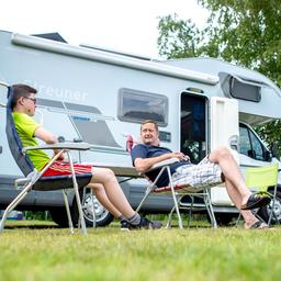 Zwei Camper vor ihrem Wohnmobil