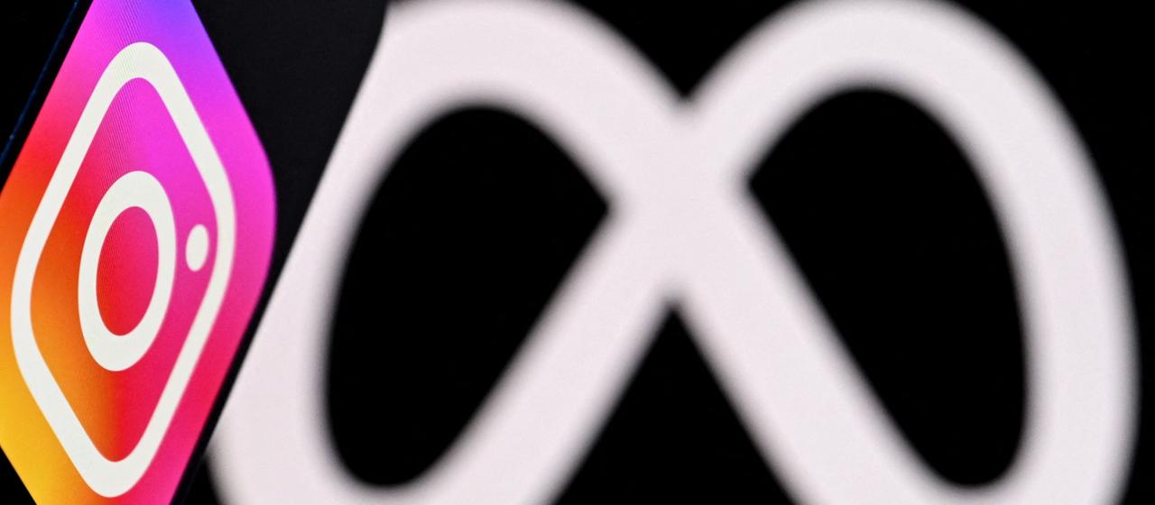 Diese Fotoillustration zeigt das Instagram-Logo des US-Sozialnetzwerks auf einem Smartphone vor dem Logo des Medienriesen Meta auf einem Laptopbildschirm.