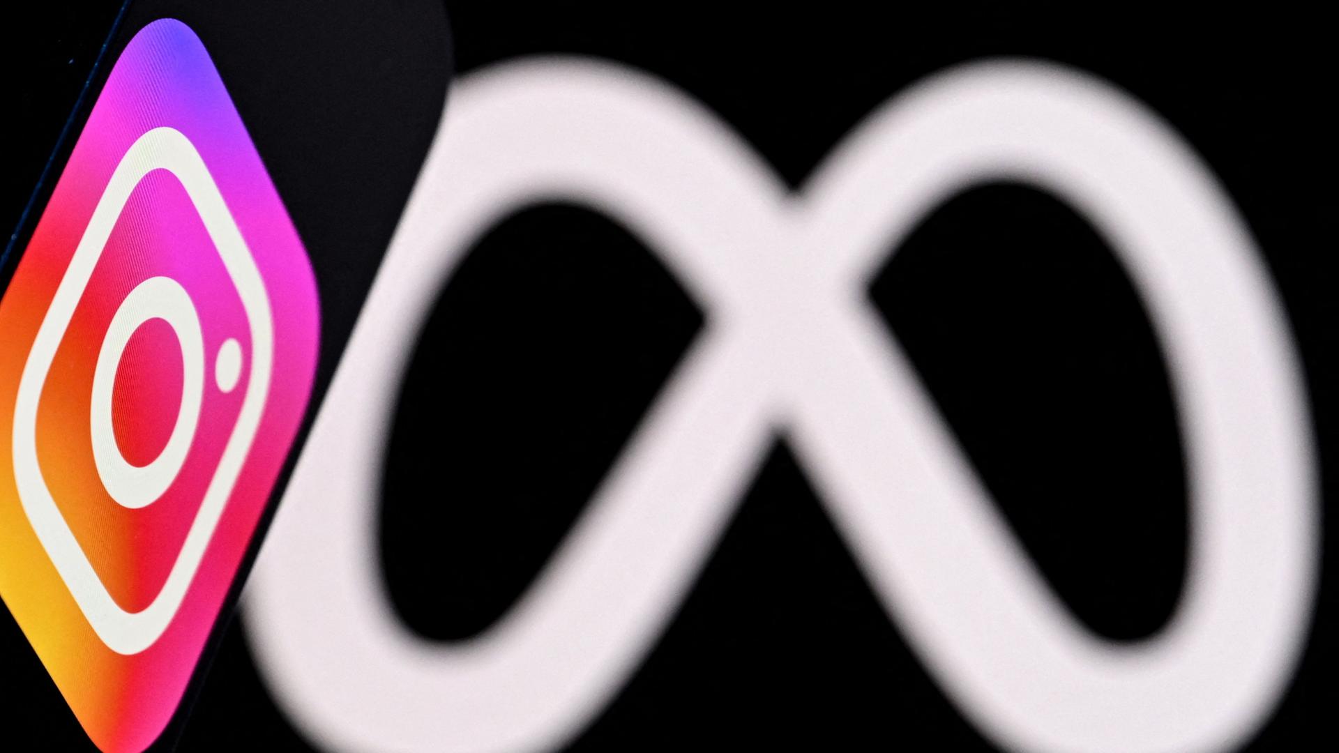 Diese Fotoillustration zeigt das Instagram-Logo des US-Sozialnetzwerks auf einem Smartphone vor dem Logo des Medienriesen Meta auf einem Laptopbildschirm. | AFP