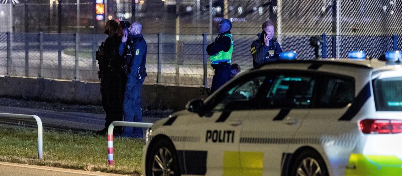 Ein Polizeiauto und mehrere Polizisten stehen am Flughafen in Kopenhagen.