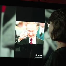 Tasnim Rödder vor einem Monitor, auf dem ein Bild von Putin in einem TikTok-Stream zu sehen ist.