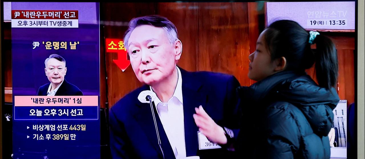 Eine Frau geht in Südkorea an einem Fernseher vorbei, auf dem Yoon Suk Yeol zu sehen ist