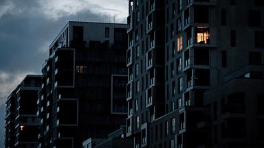 In einem Wohnhaus brennt am Morgen in einer Wohnung Licht.