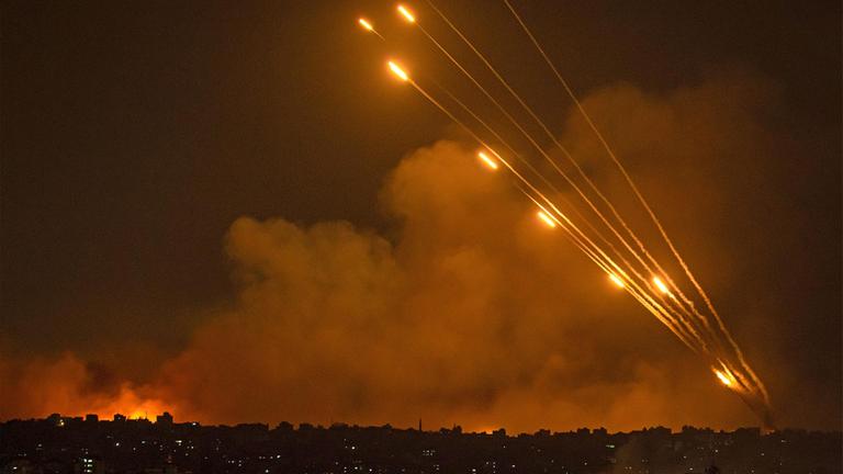 Feuer, Rauch und Raktenabwehrfeuer über einer Stadt in Gaza.