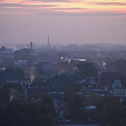 Schornsteine qualmen im frühen Morgenlicht über den Dächern von Leipzig. 