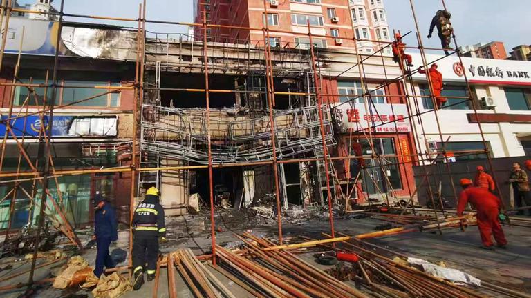 Auf diesem von der Nachrichtenagentur Xinhua veröffentlichten Foto bauen Arbeiter am Dienstag, den 29. April 2025, ein Gerüst um den Brandherd eines Restaurants in Liaoyang in der nordostchinesischen Provinz Liaoning auf.