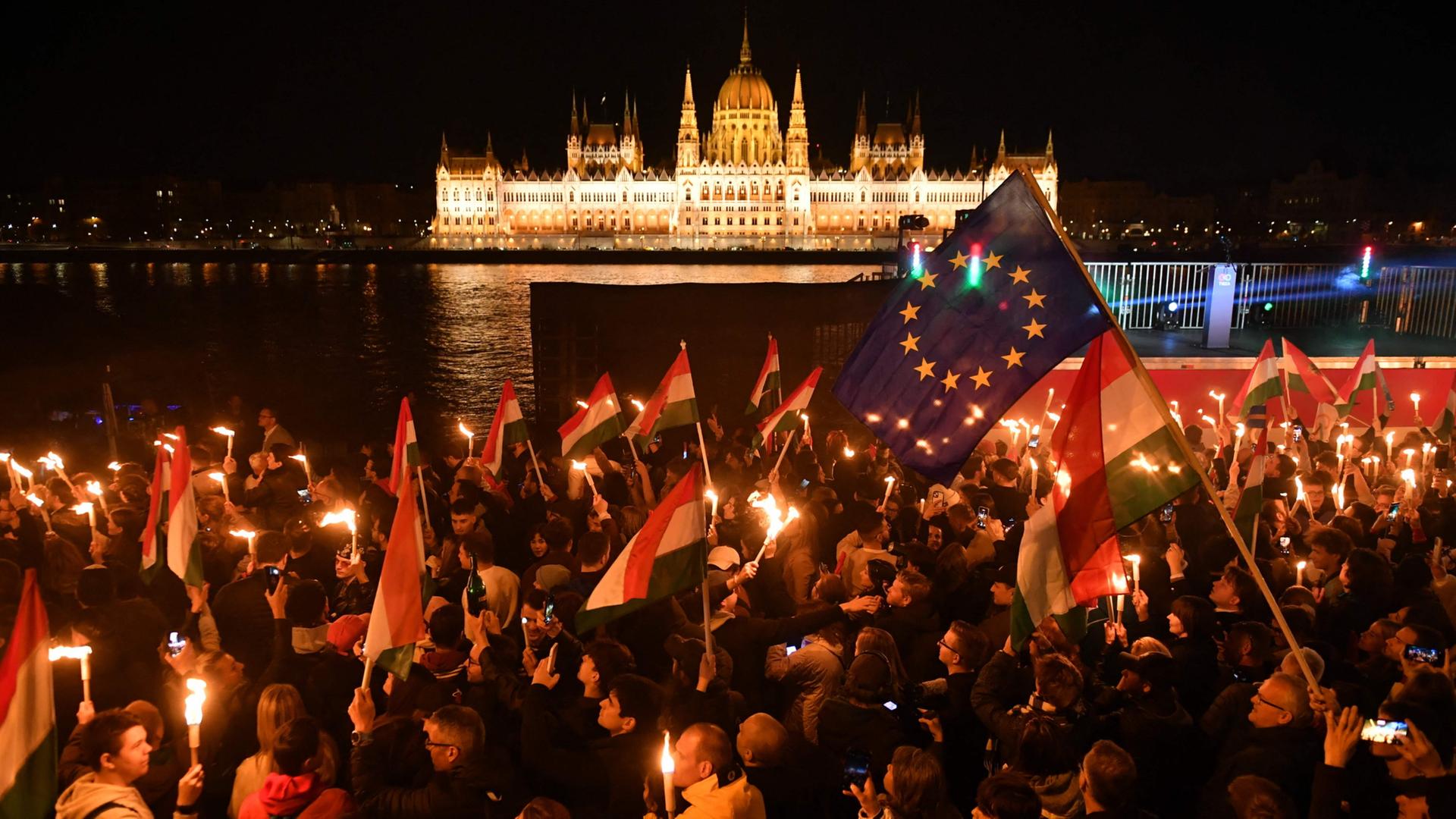Magyar-Anhänger mit einer EU- und einer Ungarn-Flagge vor Parlamentsgebäude in Budapest | AFP