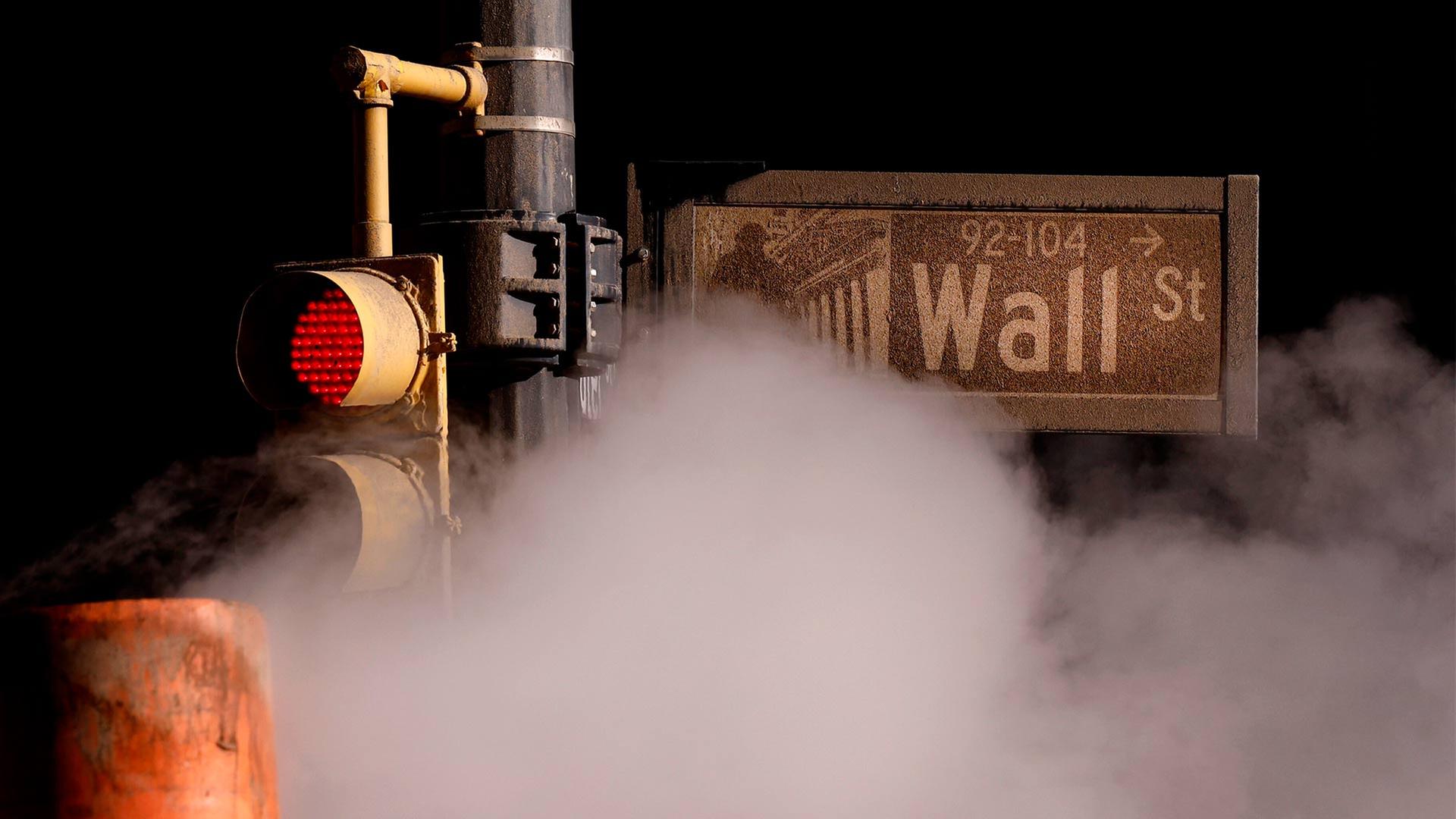 Dampf aus einem Rohr strömt unter einem Schild für die Wall Street in der Nähe der New Yorker Börse hindurch. | picture alliance / newscom