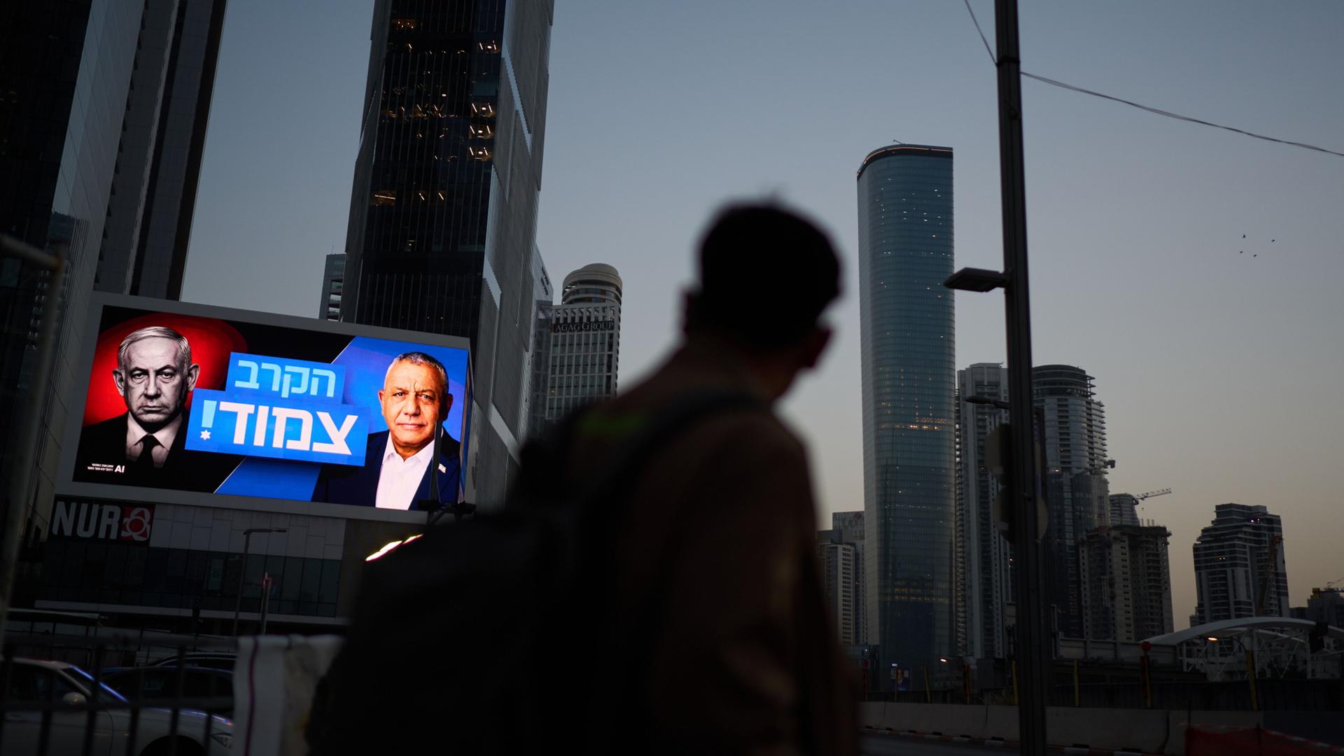 Ein Fußgänger geht an einer Wahlplakatwand vorbei, auf der Benjamin Netanjahu und Gadi Eisenkot zu sehen sind. | AP Photo/David Goldman