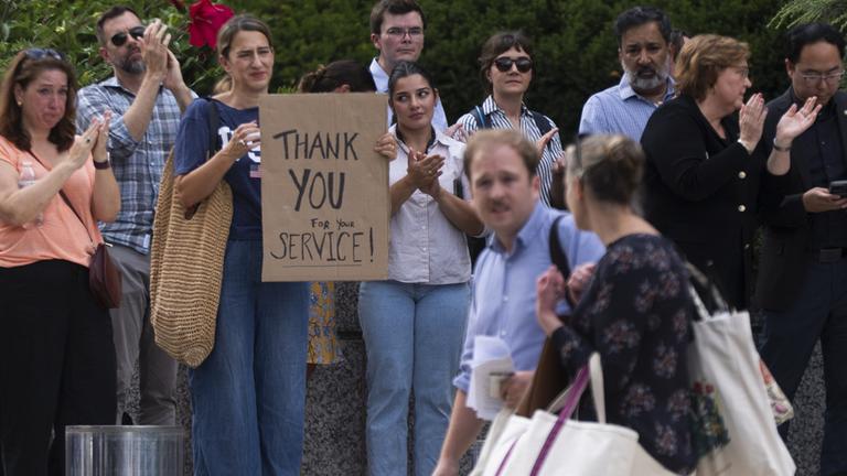 Menschen applaudieren den gekündigten Mitarbeitern des US-Außenministeriums.