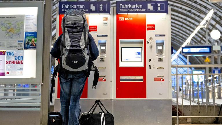 Ein Fahrgast steht im Hauptbahnhof vor einem Fahrkartenautomaten.