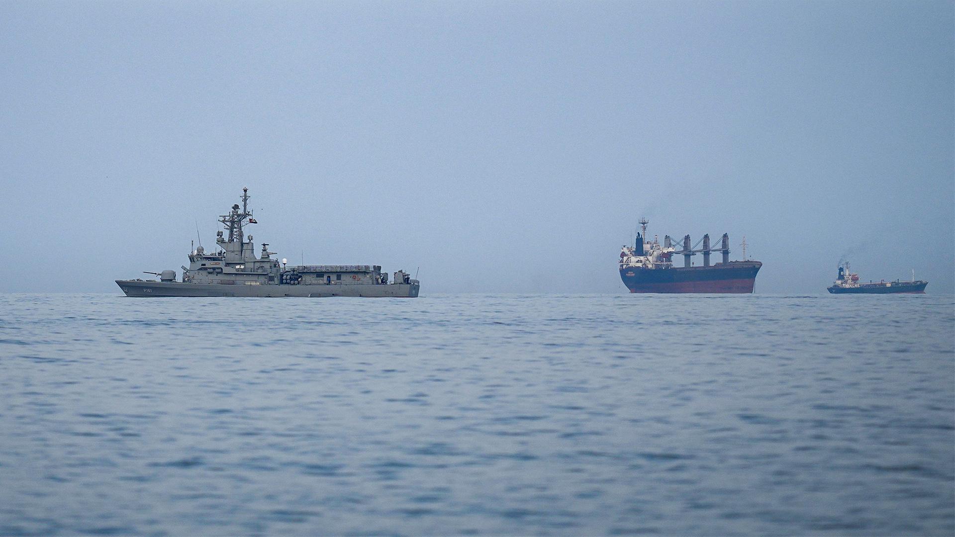 Ein Schiff der Marine der Vereinigten Arabischen Emirate neben Frachtschiffen und Öltankern. | Altaf Qadri/AP/dpa