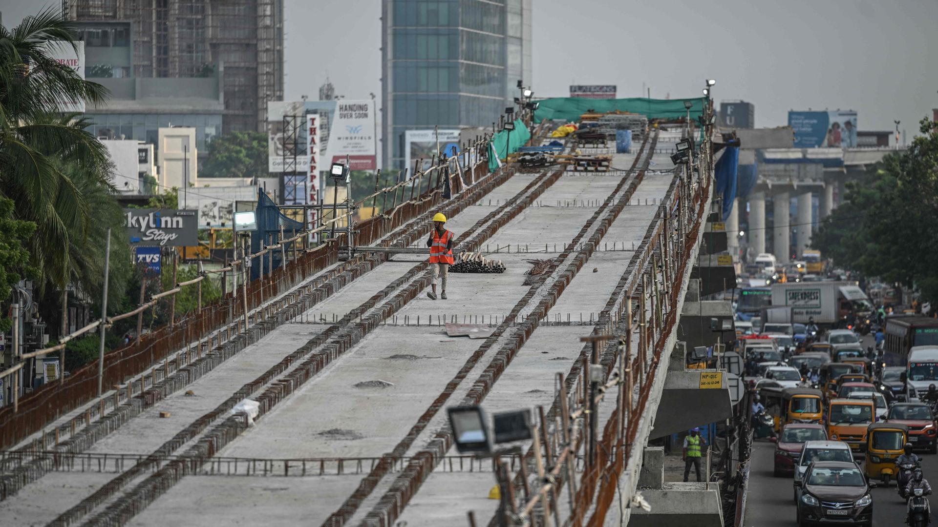 Ein Arbeiter läuft über die Baustelle der Chennai Metro Rail (Indien). | AFP