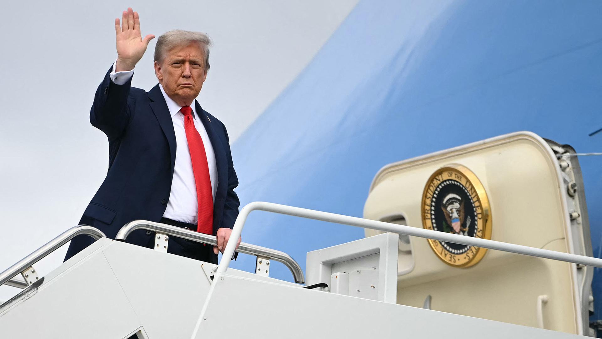 Donald Trump winkt, bevor er in die Air Force One einsteigt. | AFP