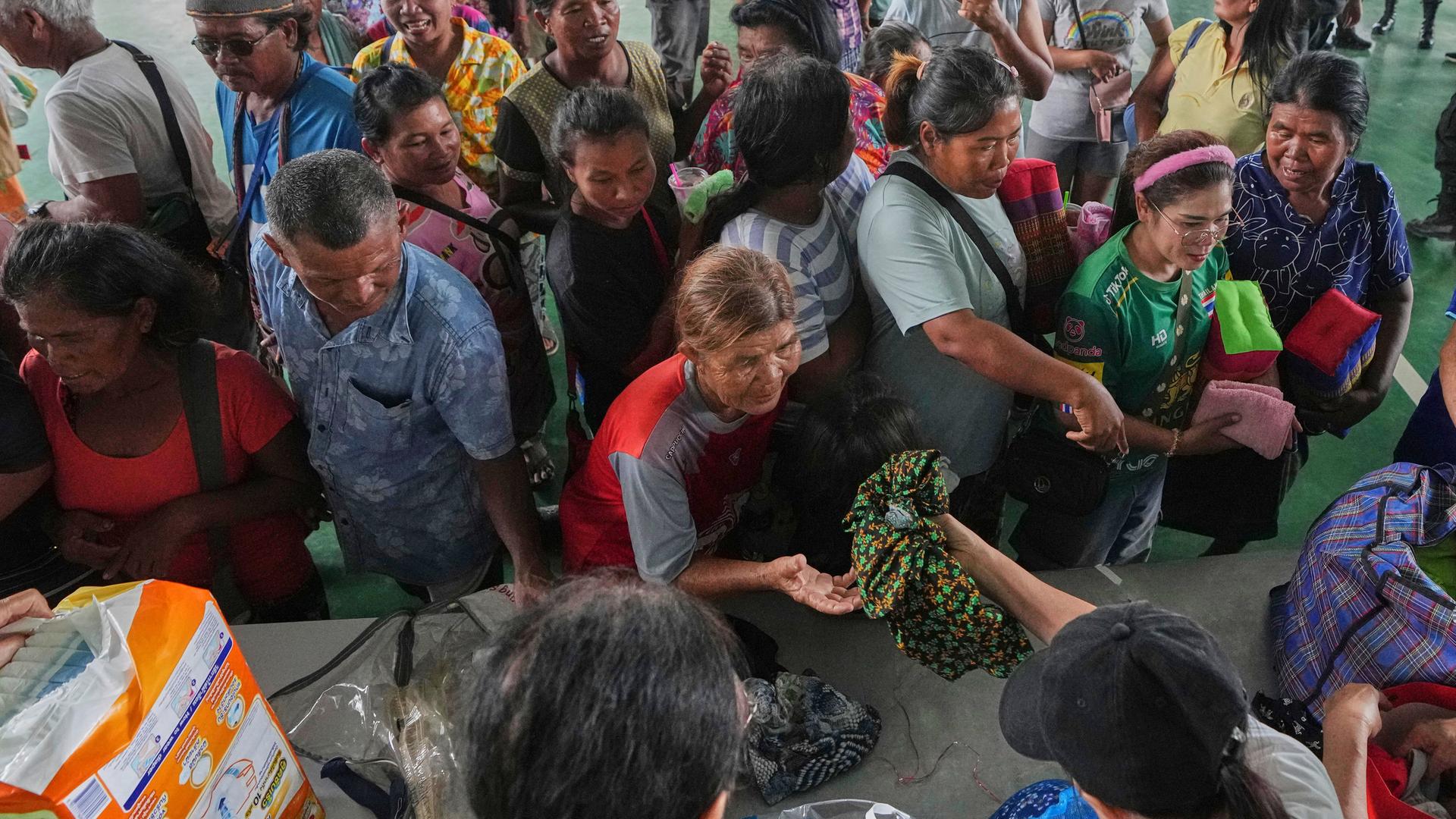 Menschen in Surin/Thailand stehen an einer Ausgabe für Toilettenartikel an. | AP