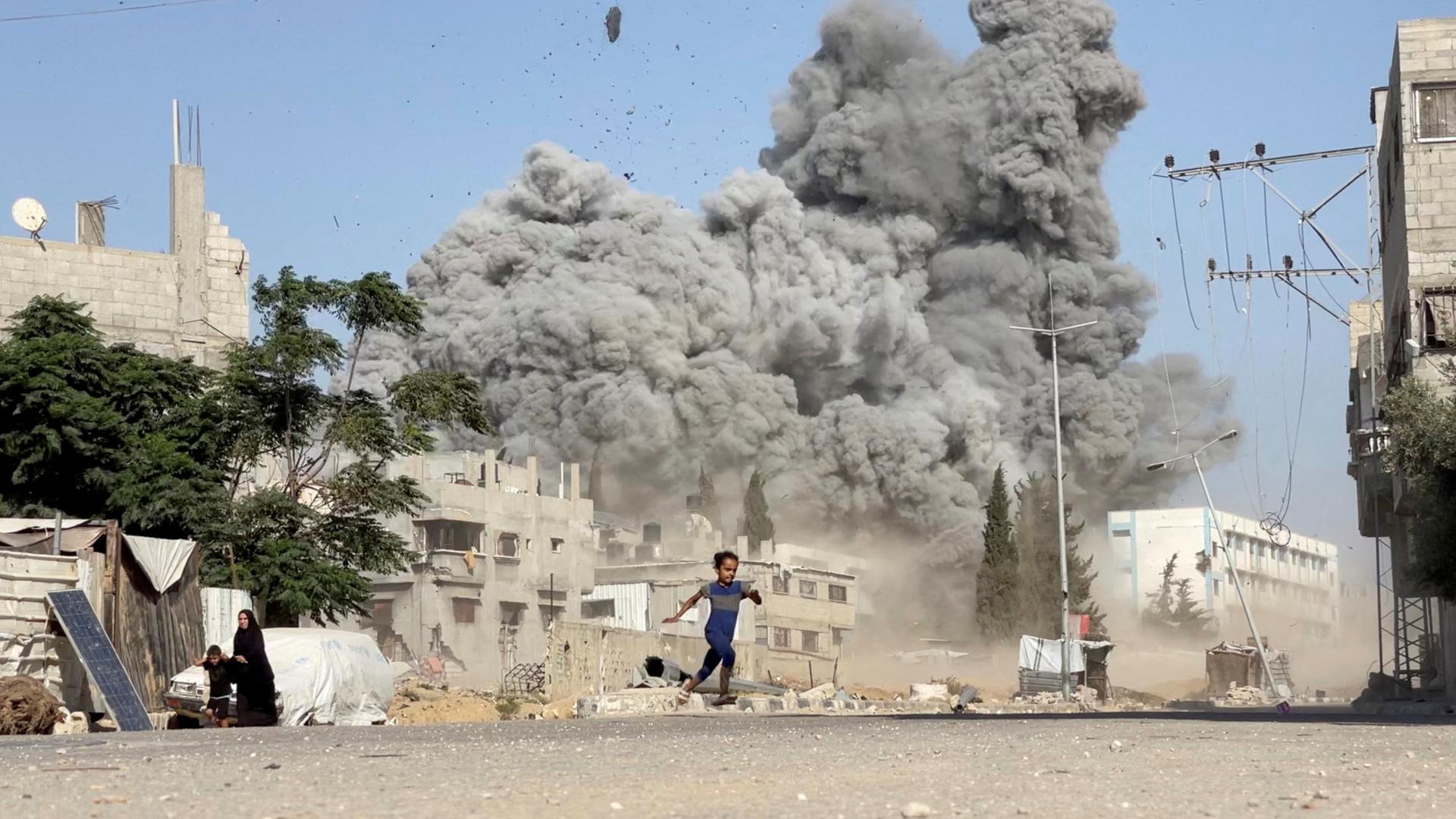 Ein Mädchen rennt vor einem Angriff im Gazastreifen davon. | REUTERS
