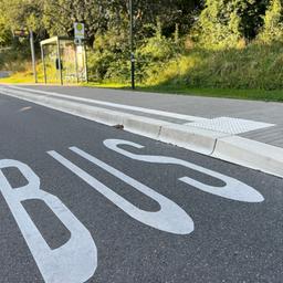 Eine Busspur auf der Straße und eine Bushaltestelle.