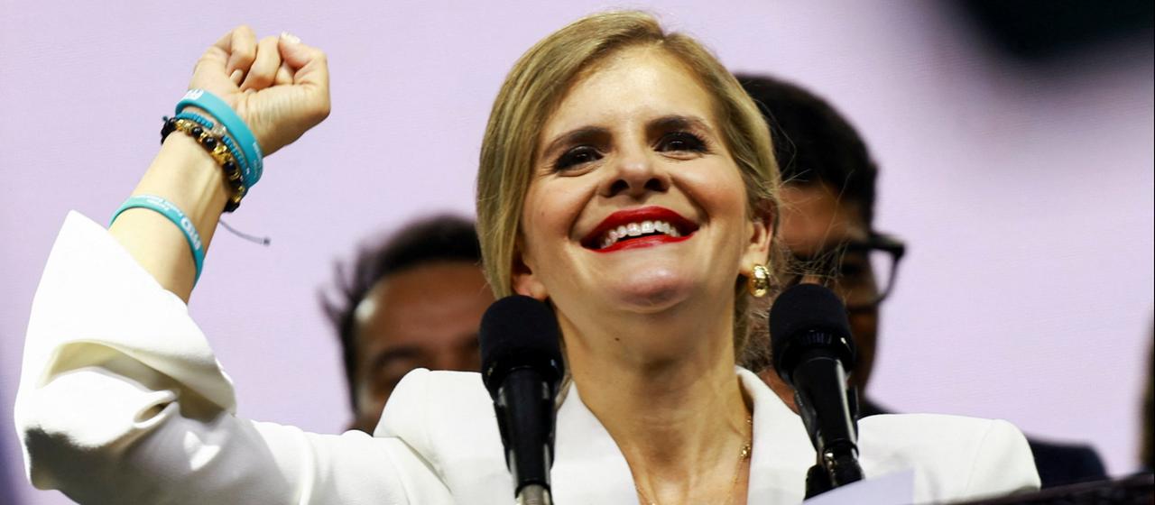 Die Präsidentschaftskandidatin Laura Fernández reckt während einer Rede triumphierend die Faust in die Höhe.