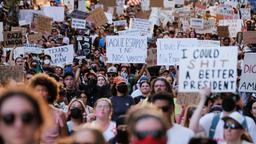 Protestierende halten Schilder während einer Kundgebung in Austin, Texas, USA hoch.