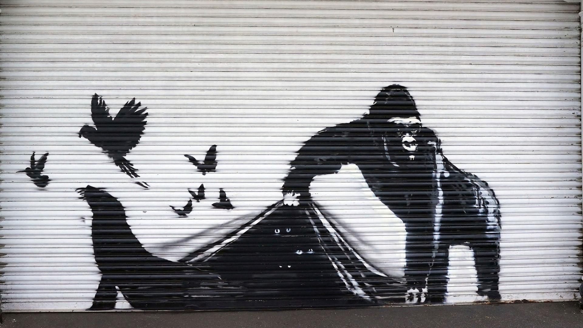 Bekanntes Banksy-Motiv auf einer Mauer