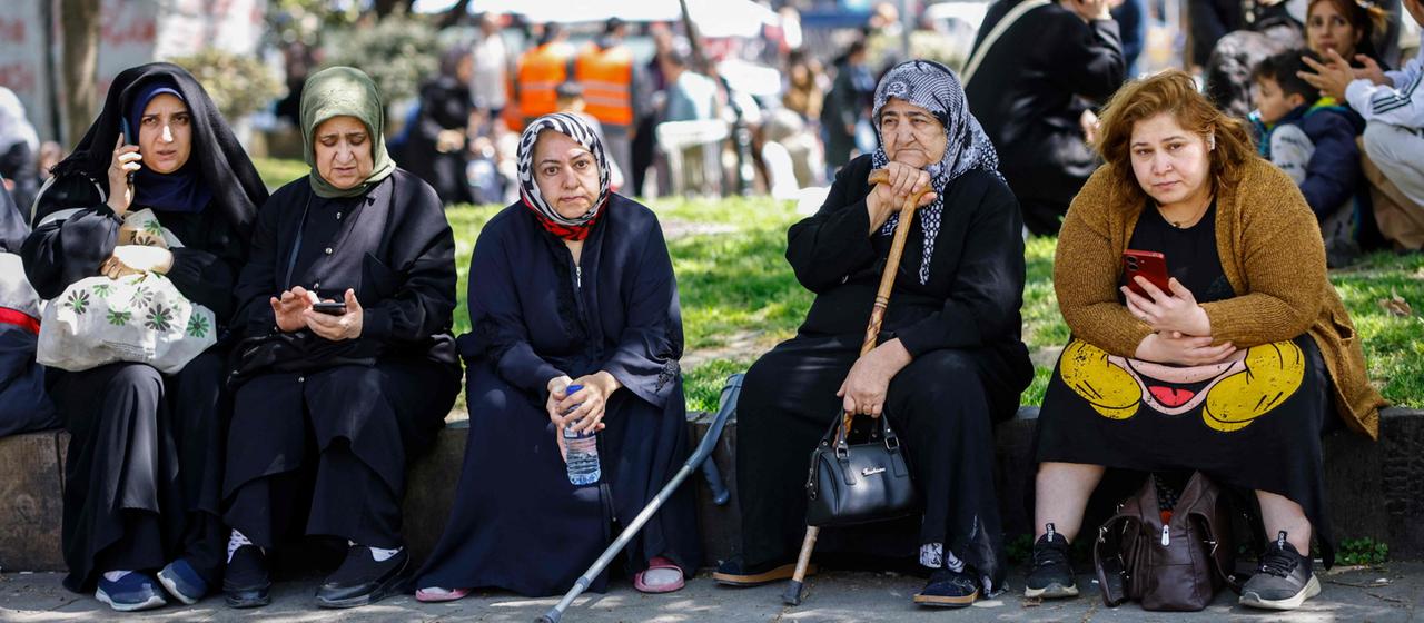 Menschen sitzen im Freien nach Erdbeben in Istanbul