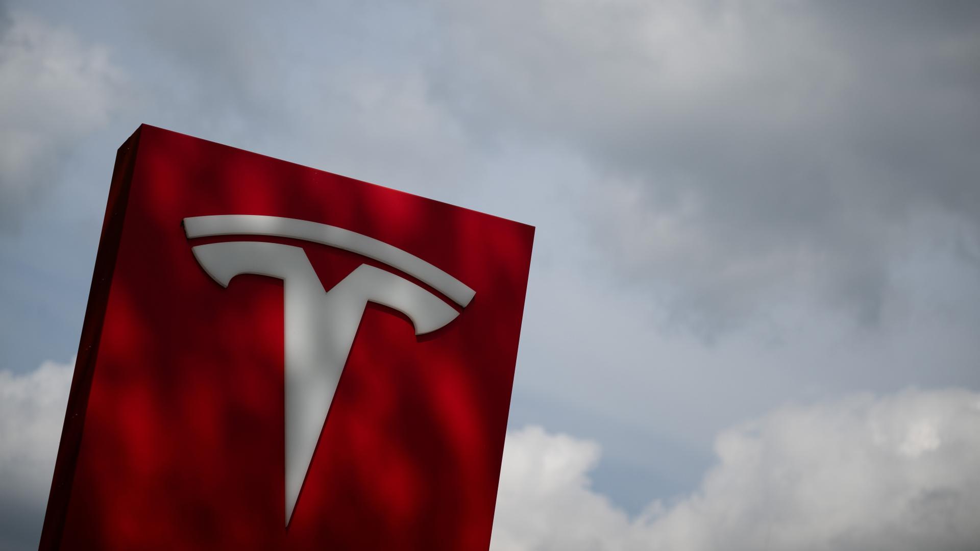 Das Tesla-Logo steht an einem Autohaus. | dpa