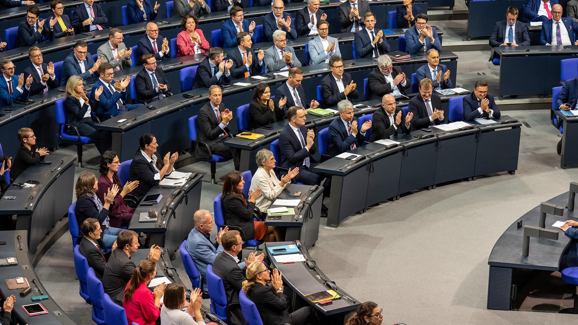 Abgeordnete klatschen im Plenarsaal des Bundestags. | dpa