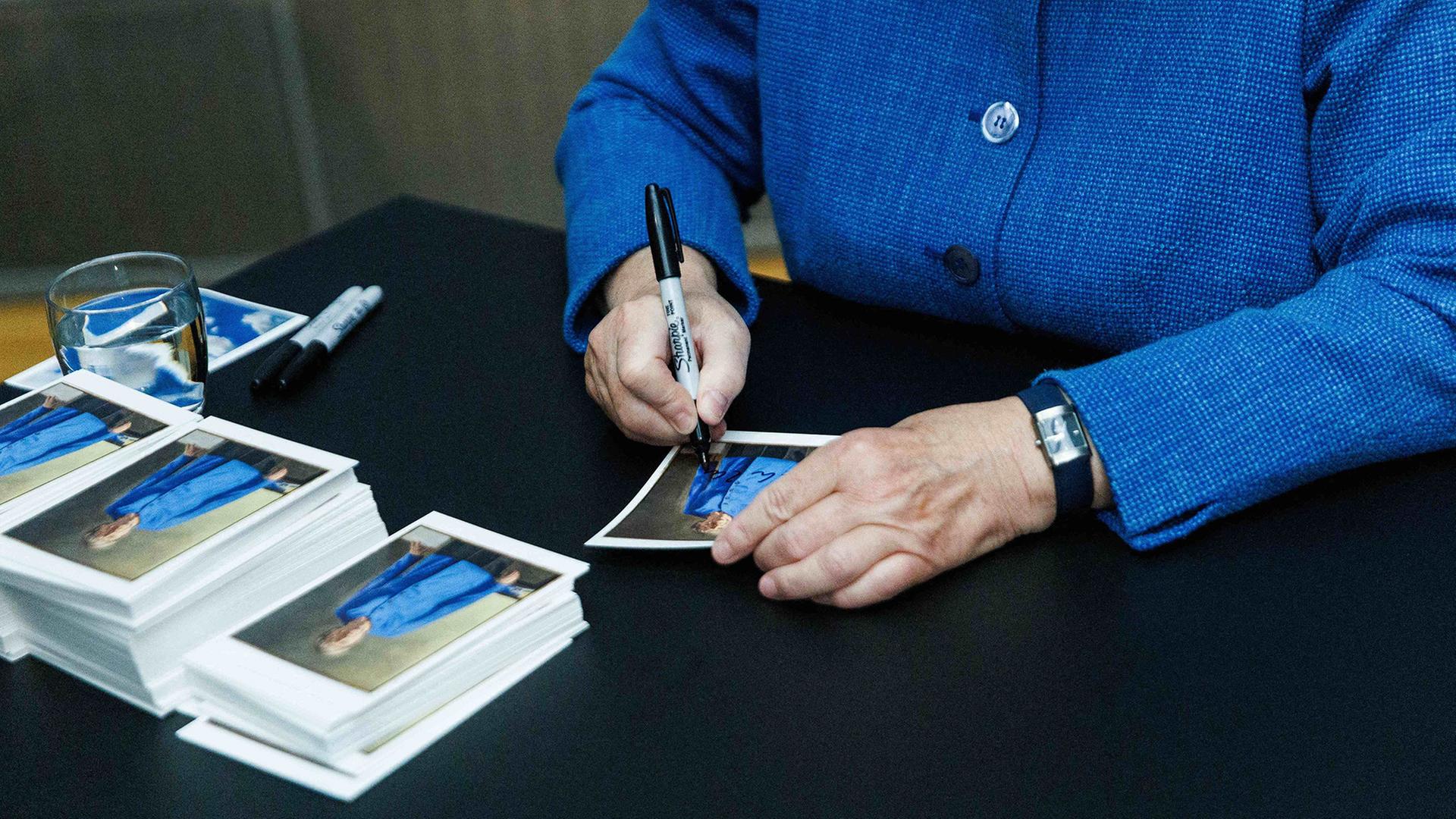 Angela Merkel signiert Kunstpostkarten mit ihrem PortrÃ¤t | Carsten Koall/dpa
