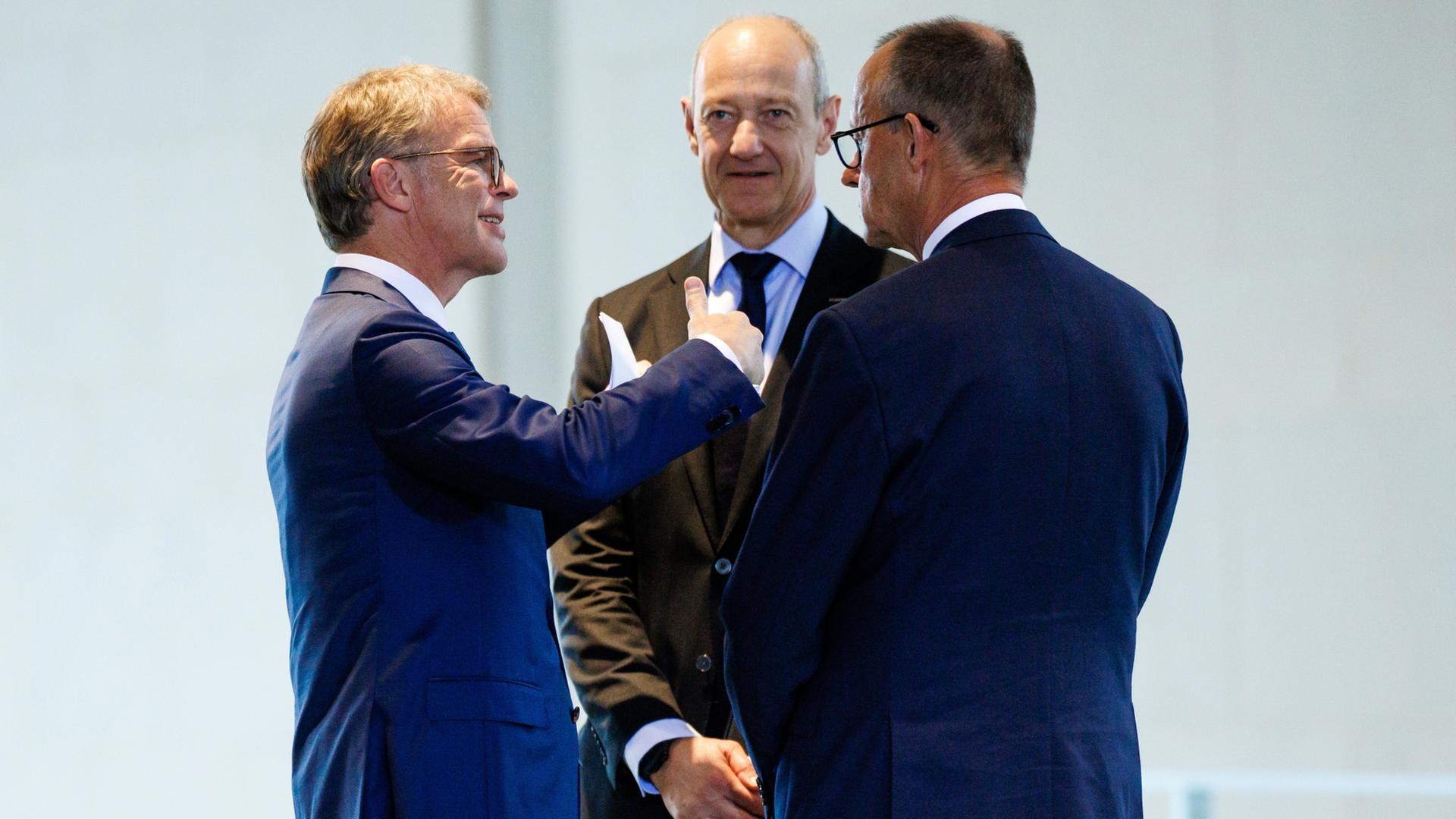 Christian Sewing (links), Roland Busch (Mitte) und Friedrich Merz (rechts) | EPA
