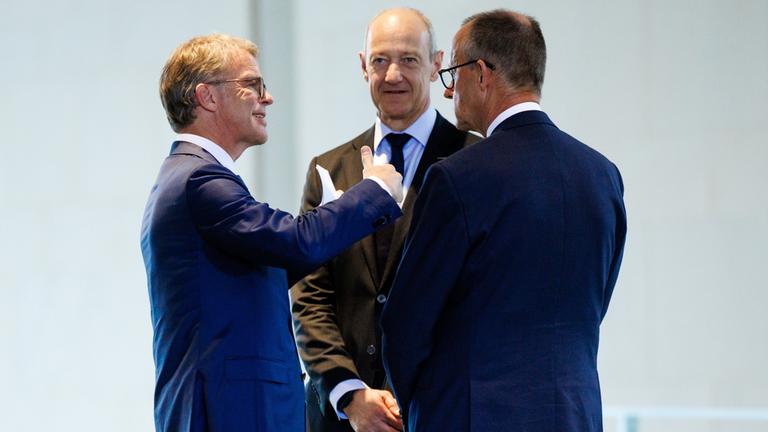 Christian Sewing (links), Roland Busch (Mitte) und Friedrich Merz (rechts)