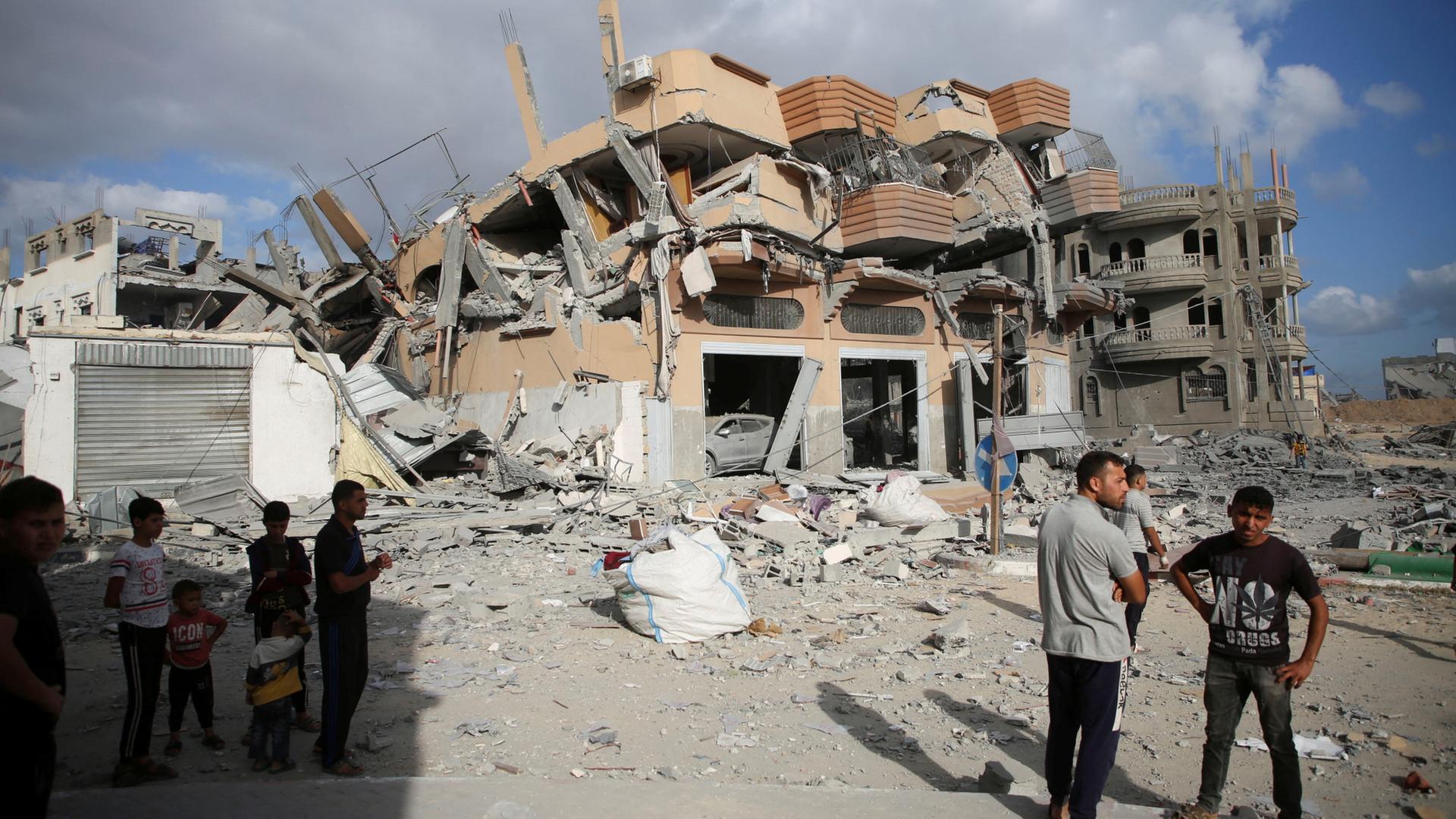 Menschen vor Ruine in Can Yunis