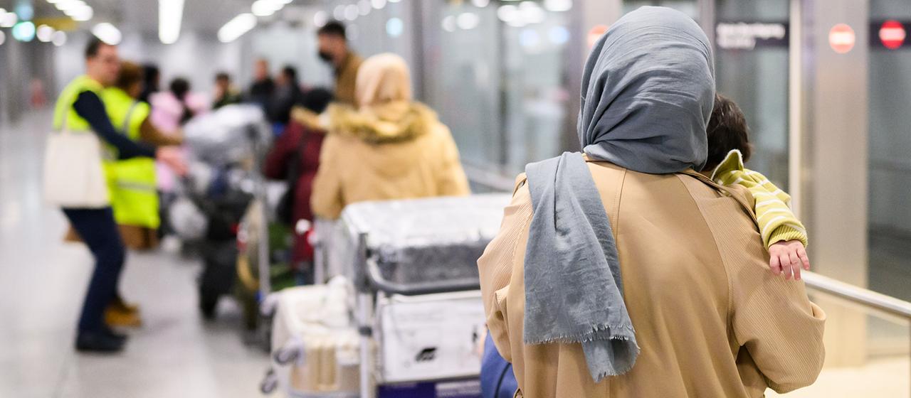 Afghaninnen und Afghanen aus den Bundesaufnahmeprogrammen stehen im Flughafen Hannover. 