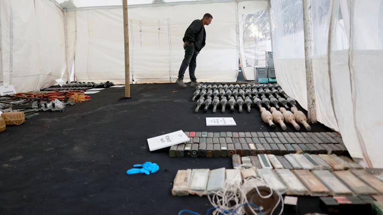 Ein Mann betrachtet Waffen und militärische Ausrüstung, die nach Angaben des israelischen Militärs von Hamas-Bewaffneten aus dem Gazastreifen eingesetzt wurden