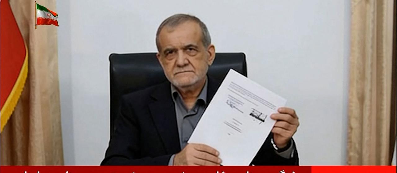 Dieser Screenshot des iranischen Staatsfernsehens zeigt Irans Präsident Massud Peseschkian, wie er ein Dokument hält, das ein Memorandum of Understanding zeigt.