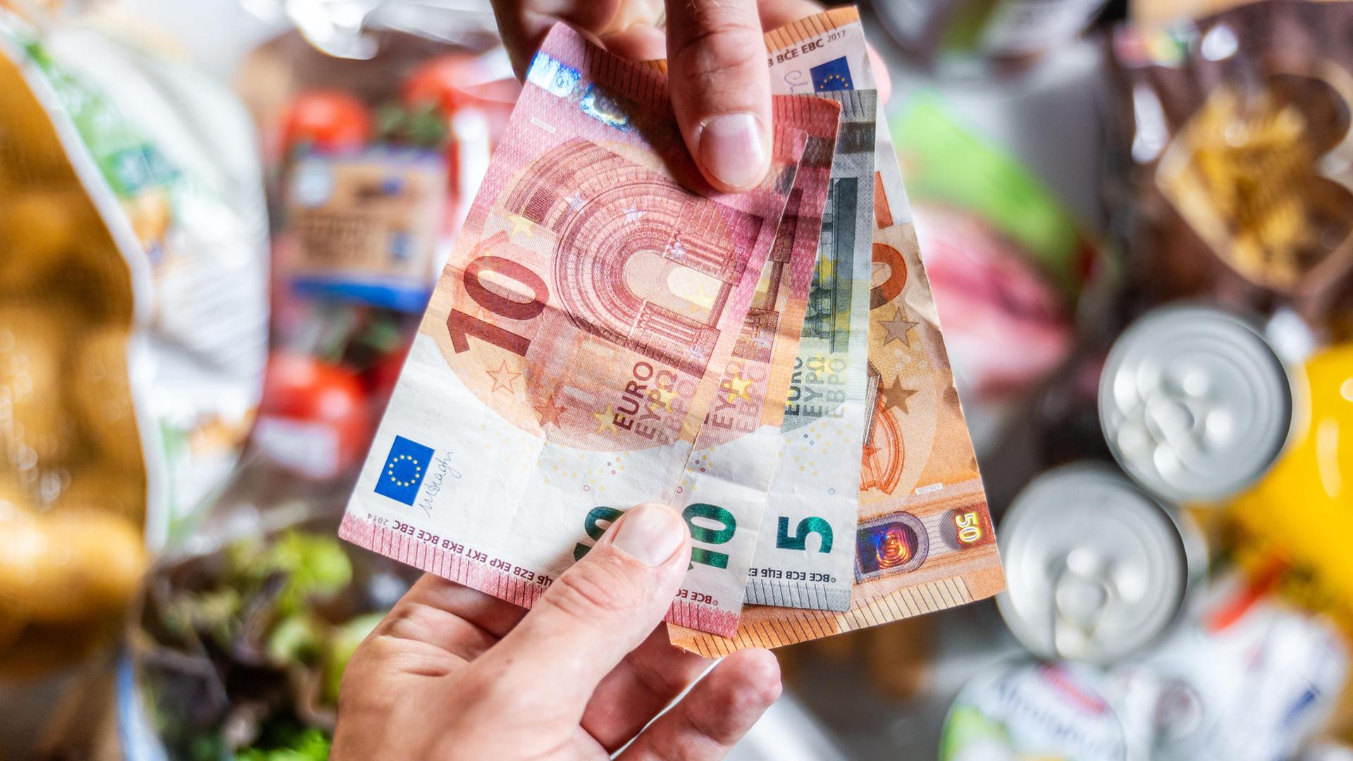Ein Kunde bezahlt seinen Einkauf im Supermarkt bar mit Euro-Geldscheinen | picture alliance / CHROMORANGE |