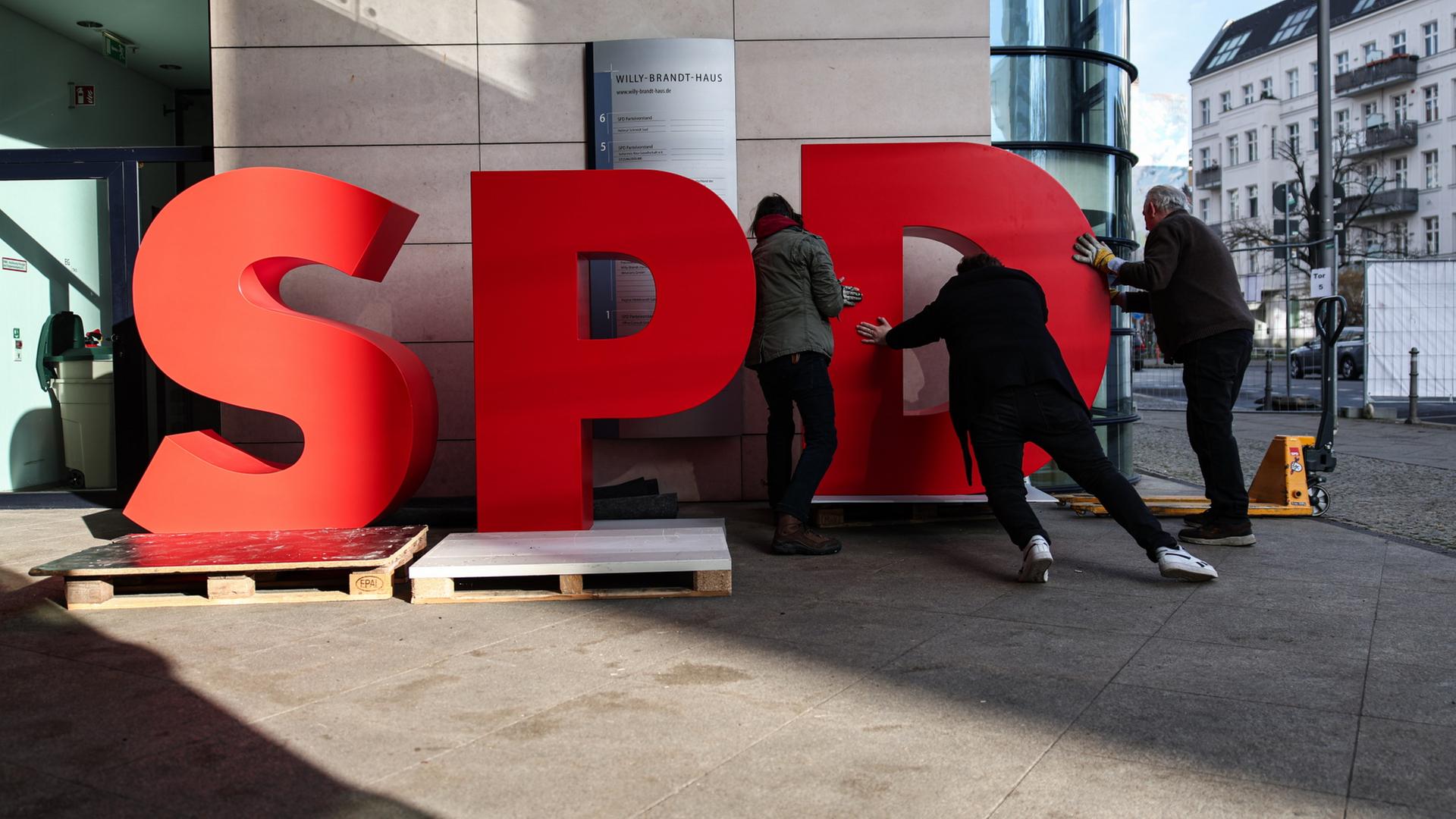 Arbeiter demontieren einen SPD-Schriftzug vor dem Willy-Brandt-Haus. | dpa