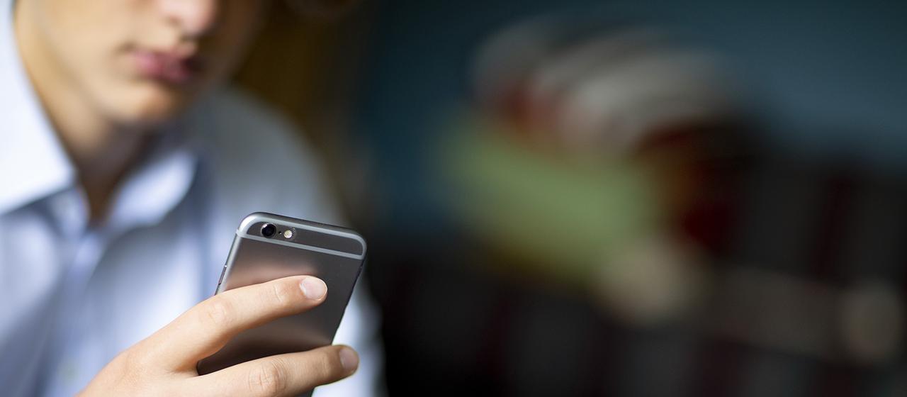 Ein Mann hält ein Handy in der Hand.