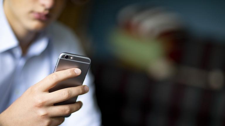 Ein Mann hält ein Handy in der Hand.