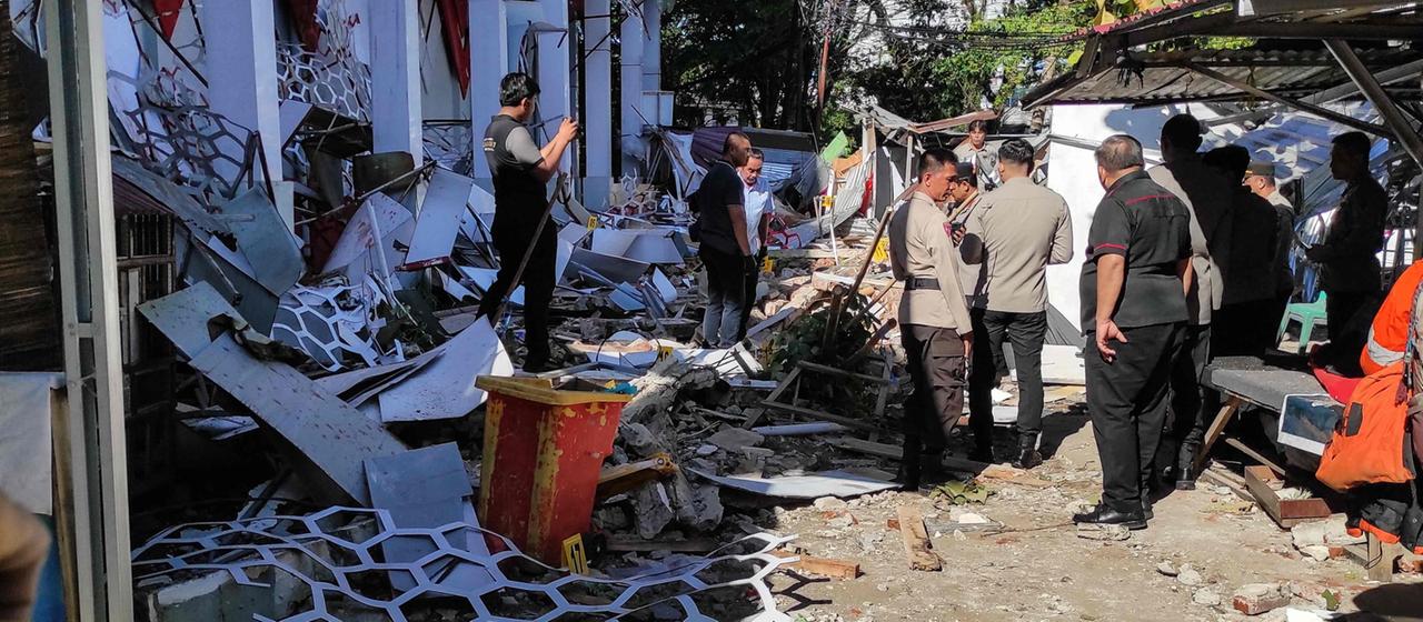 Polizisten inspizieren ein beschädigtes Gebäude nach einem Erdbeben in Manado, Nordsulawesi-