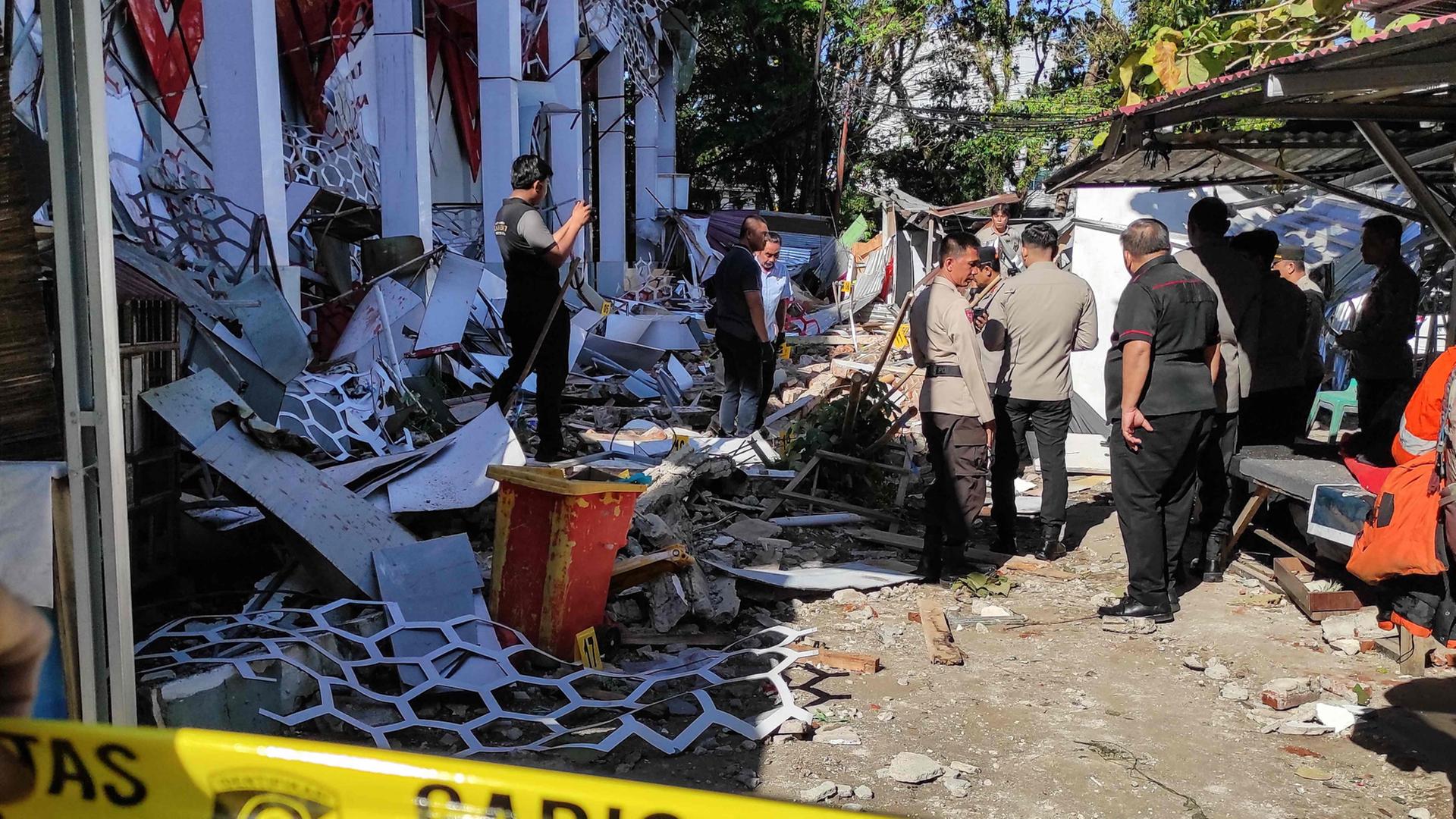 Polizisten inspizieren ein beschädigtes Gebäude nach einem Erdbeben in Manado, Nordsulawesi- | AFP