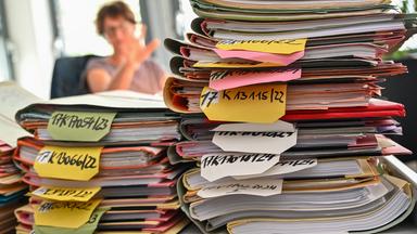 Mehrere Stapel mit Akten liegen auf einem Tisch am Finanzgericht Berlin-Brandenburg. 