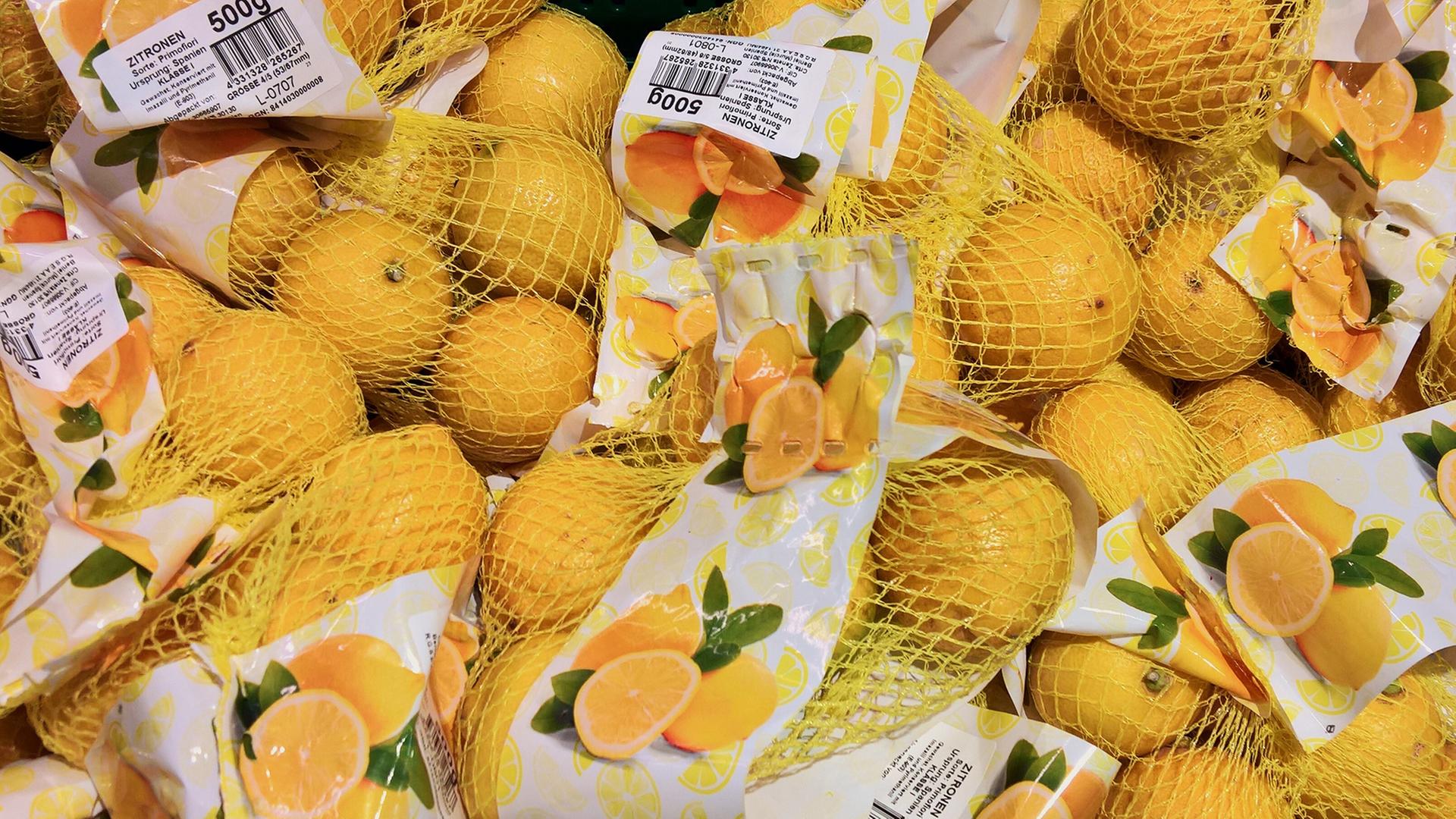 In Plastiknetzen verpackte Zitronen. | picture alliance / Manfred Seger
