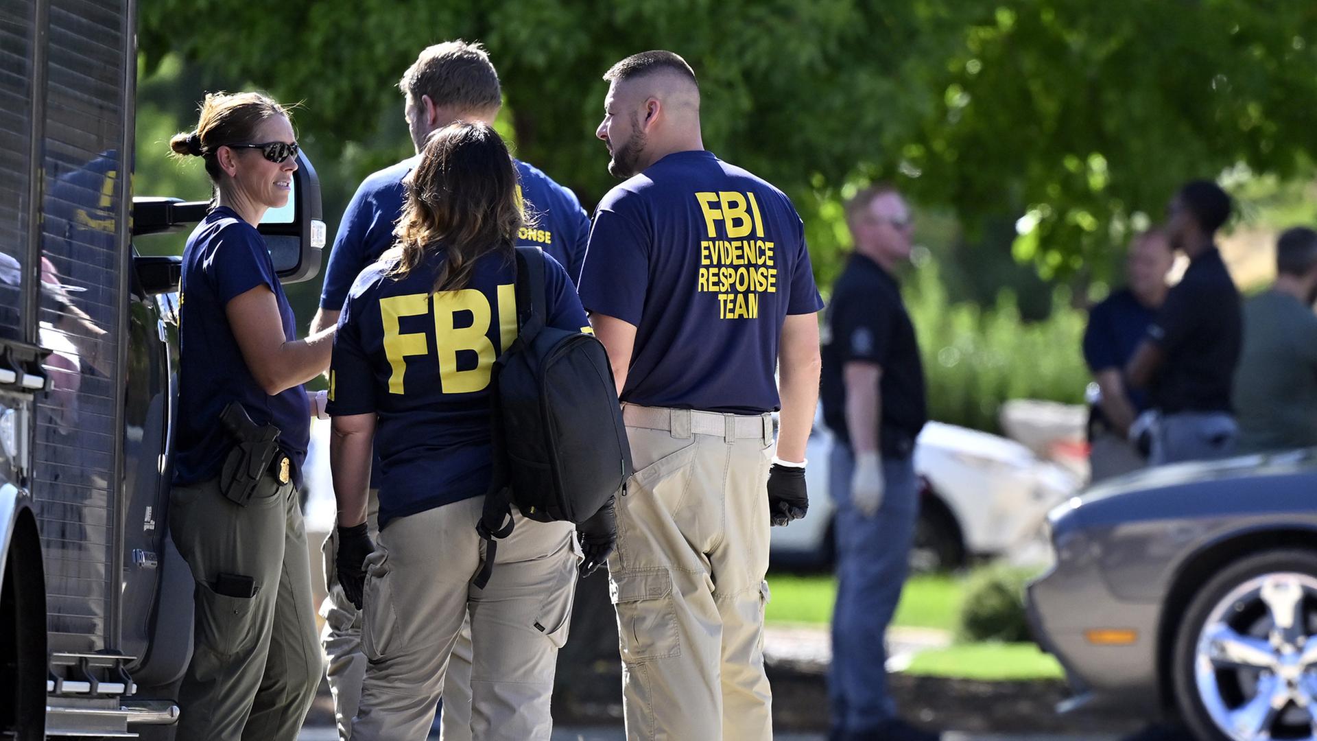 FBI-Beamte reden miteinander vor einem Fahrzeug. (Archivbild: 12.9.2025) | dpa