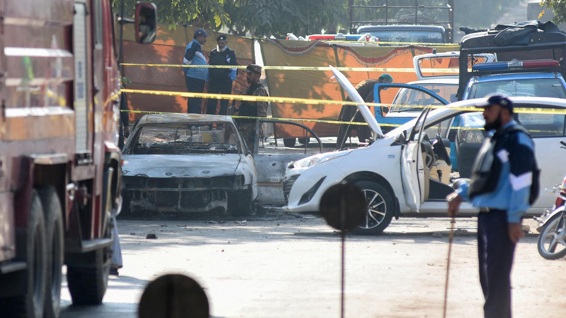 Polizisten haben das Gebiet um ein zerstörtes Fahrzeug abgesperrt. | REUTERS